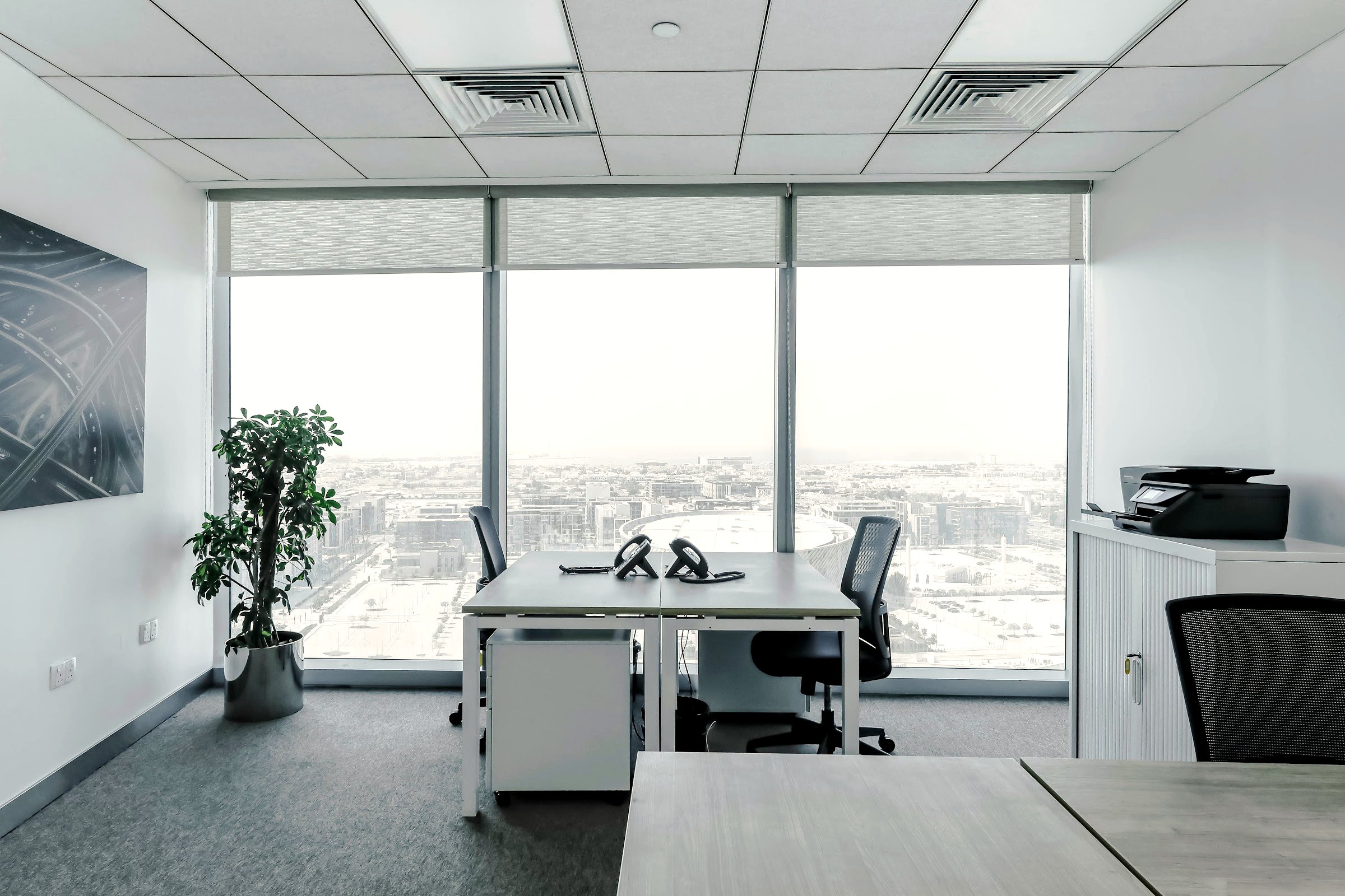 A private office with desks and floor-to-ceiling city views